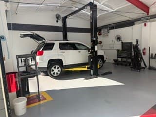 A customer's vehicle on a lift at Coopers DIY Garage